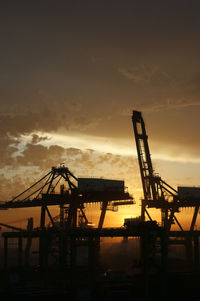 Low angle view of crane at sunset