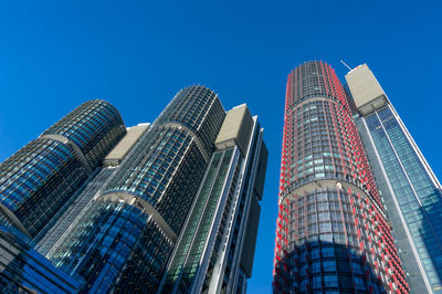 Low angle view of modern buildings against blue sky.