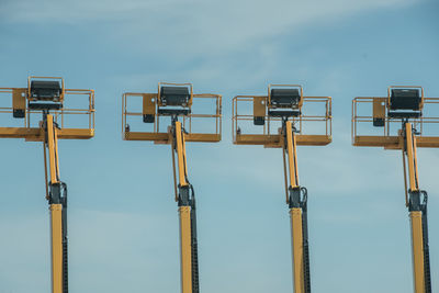 Low angle view of cranes against sky