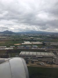 Aerial view of town against cloudy sky