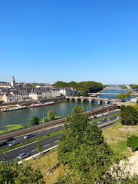 High angle view of city and river against clear blue sky