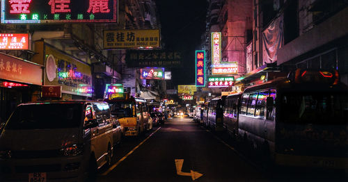 Cars on illuminated street in city at night