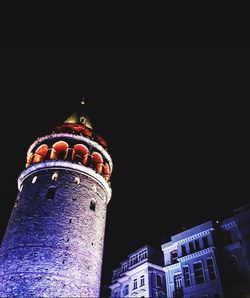 Low angle view of illuminated building against sky at night