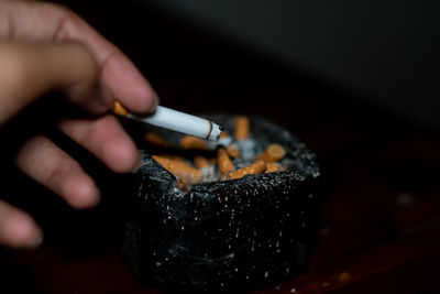 Close-up of hand holding cigarette