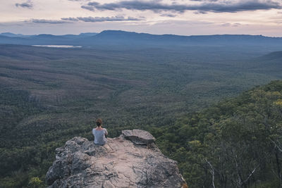 Young woman sits at the balconies admiring the vast landscape of grampians national park, victoria, australia