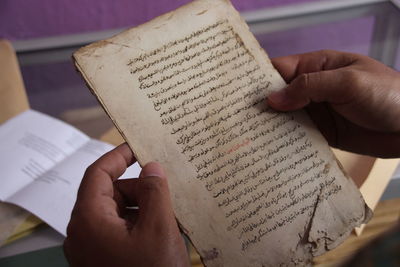 Midsection of person reading book on paper