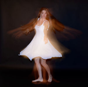 Young woman against black background