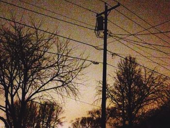 Low angle view of bare tree against sky at sunset