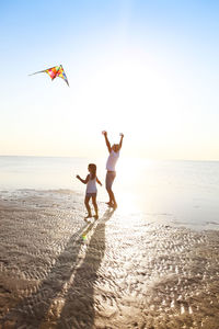 Low angle view of people on beach against sky