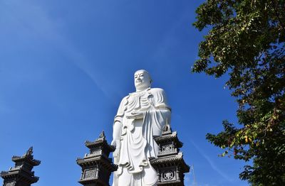 Low angle view of statue against blue sky