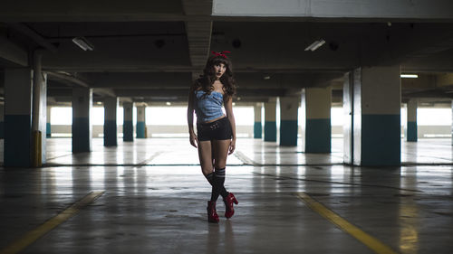 Full length portrait of young woman standing in parking lot