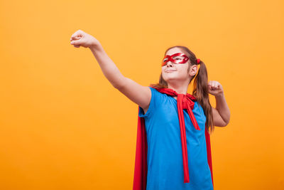 Portrait of young woman wearing sunglasses against blue background