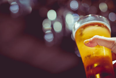 Close-up of hand holding beer glass