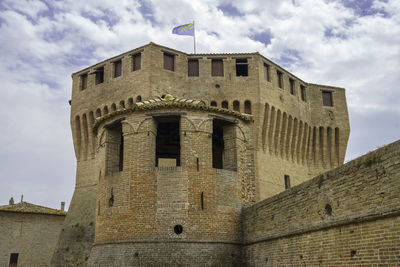 Low angle view of old building against cloudy sky