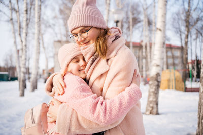 Mother and daughter happily embrace spring walk in the park sunny day