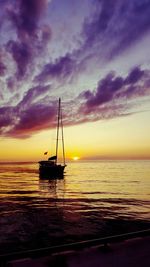 Sailboat sailing on sea against sky during sunset