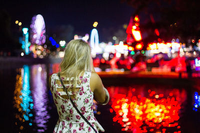 Rear view of woman with illuminated lights at night