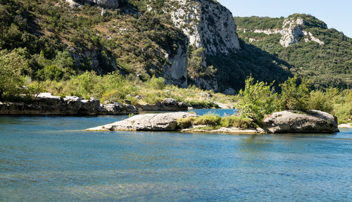 Scenic view of rocks in river against mountain