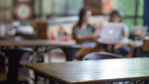 Close-up of table with people sitting in background at restaurant