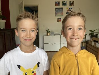 Portrait of young twin boys standing at home