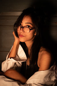 Portrait of woman sitting on bed