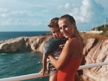 Portrait of smiling young man against sea and sky