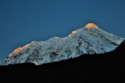 Scenic view of snowcapped mountains against clear blue sky