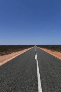 Road by landscape against clear sky