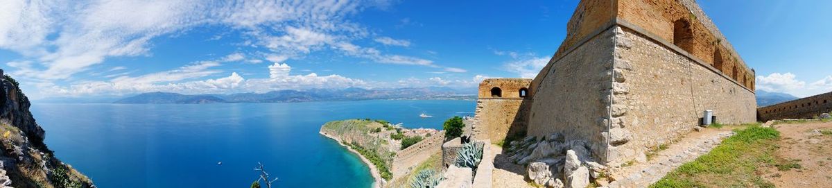 Panoramic view of historic building by sea against sky