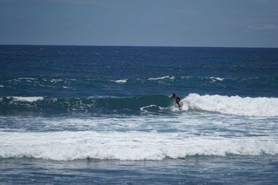 Man surfing on sea against sky