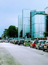 Traffic on city street by buildings against sky