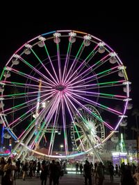 Low angle view of illuminated ferris wheel against sky at night