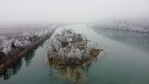 Scenic view of lake against sky during foggy weather