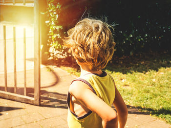 Rear view of boy standing outdoors