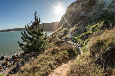 Dad and preschool age child walking on mountain path in new zealand