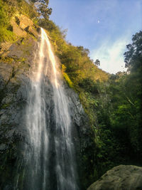 Scenic view of waterfall against sky