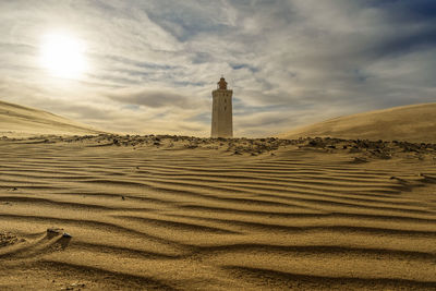 View of lighthouse on beach against sky