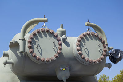 Low angle view of clock against clear blue sky
