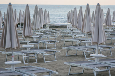 Deck chairs with parasols arranged at beach
