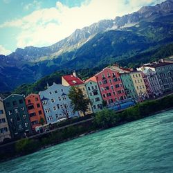 Town by river with mountains in background