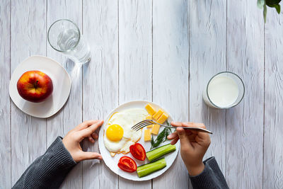 Healthy breakfast.  boy's hands are holding a fork, over a plate with fried eggs