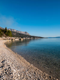 Scenic view of sea against clear blue sky