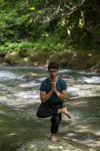 Full length of young man exercising in lake