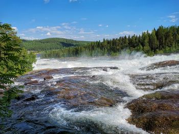 Scenic view of waterfall against sky