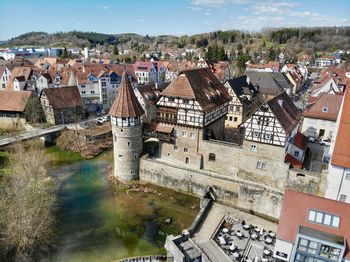 High angle view of townscape by river in city