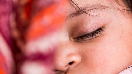 Close-up of cute baby girl sleeping at home