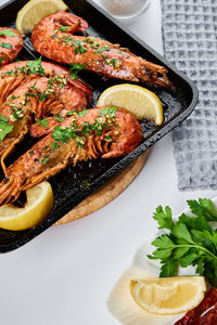 Grilled large queen shrimps with lemon and spices on grill pan