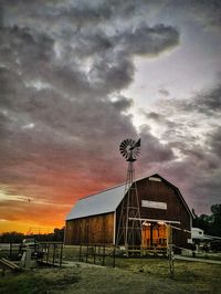 Houses against cloudy sky at sunset