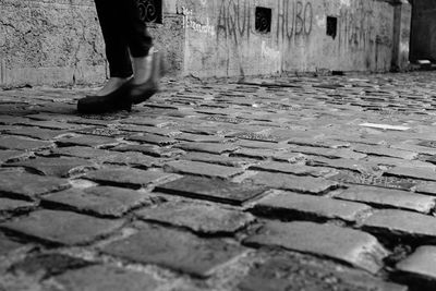 Low section of man standing on cobblestone