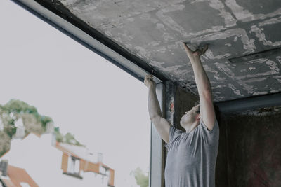 Caucasian male builder clean the window opening.
